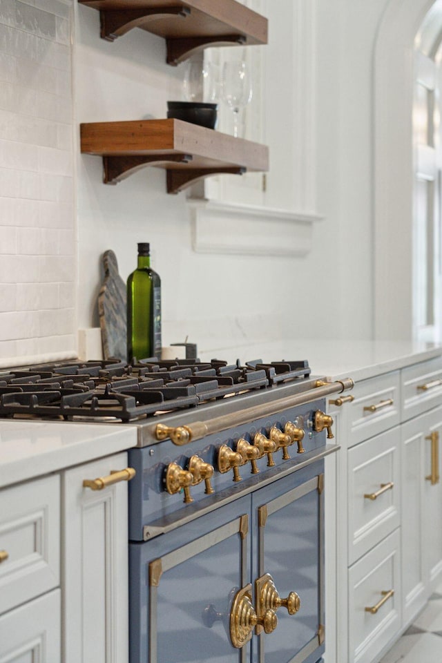 71 E Bay St, Charleston, SC 29401 - kitchen with double oven range, white cabinetry, light countertops, and tasteful backsplash
