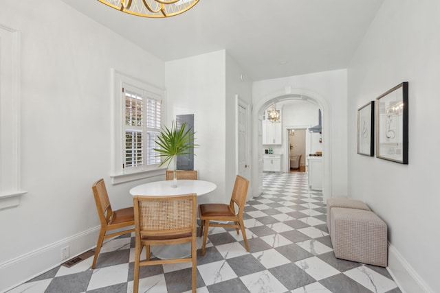 71 E Bay St, Charleston, SC 29401 - dining space with a chandelier, baseboards, and arched walkways