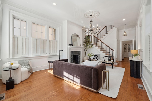 71 E Bay St, Charleston, SC 29401 - living room featuring a premium fireplace, baseboards, a chandelier, wood finished floors, and stairs