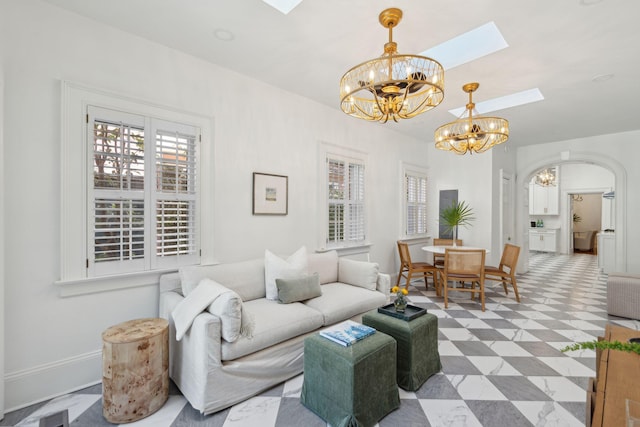71 E Bay St, Charleston, SC 29401 - living room featuring a chandelier, a skylight, baseboards, and light floors