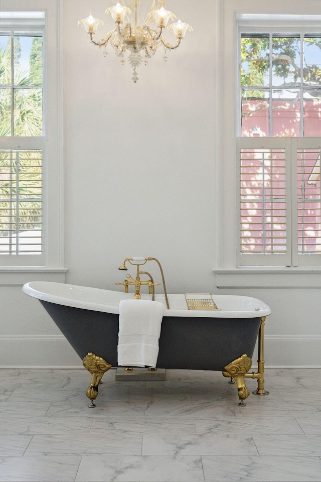 71 E Bay St, Charleston, SC 29401 - full bath featuring a chandelier, a soaking tub, baseboards, and marble look tiles