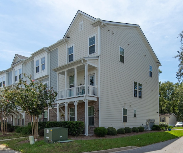 view of front of home with a balcony and a front lawn