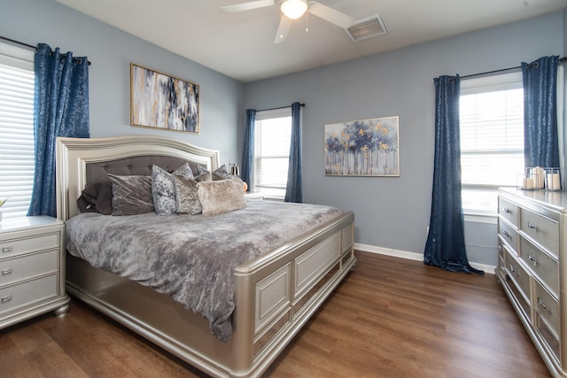 bedroom with multiple windows, dark hardwood / wood-style floors, and ceiling fan