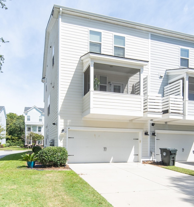 townhome / multi-family property with a balcony, a front yard, and a garage