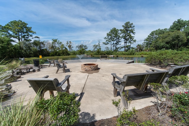 exterior space with a water view, a patio area, and an outdoor fire pit