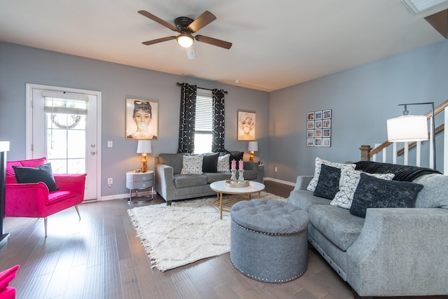 living room featuring ceiling fan and dark wood-type flooring