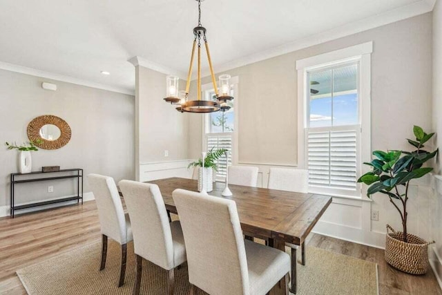 dining space featuring ornamental molding, a notable chandelier, and light hardwood / wood-style floors