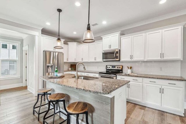 kitchen featuring white cabinets, appliances with stainless steel finishes, sink, and stone counters