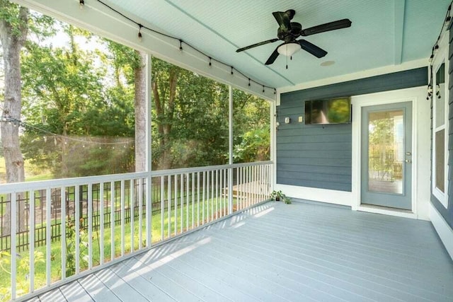 unfurnished sunroom with ceiling fan