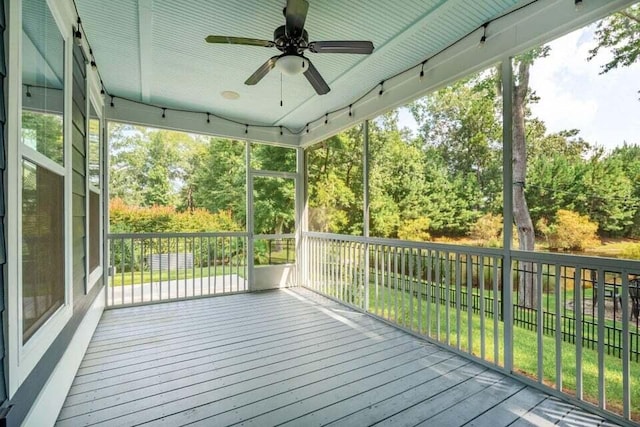 wooden terrace with ceiling fan and a yard