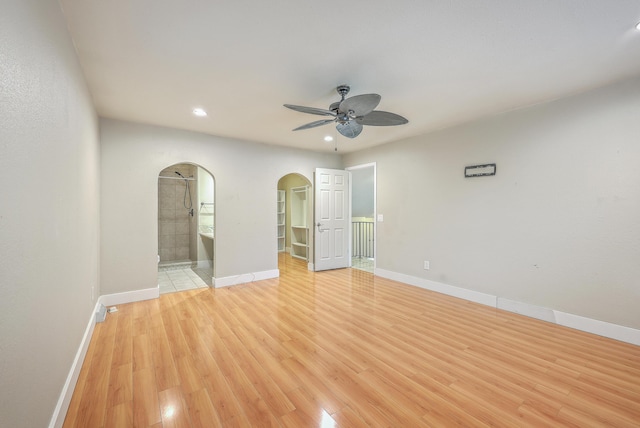 unfurnished bedroom featuring light hardwood / wood-style floors, ceiling fan, and ensuite bathroom