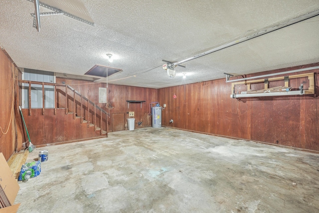 garage featuring wood walls and electric water heater