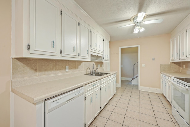 kitchen with dishwasher, stove, white cabinetry, and sink