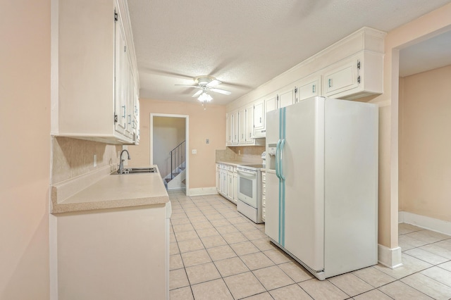 kitchen featuring white cabinetry, white appliances, sink, and light tile patterned floors