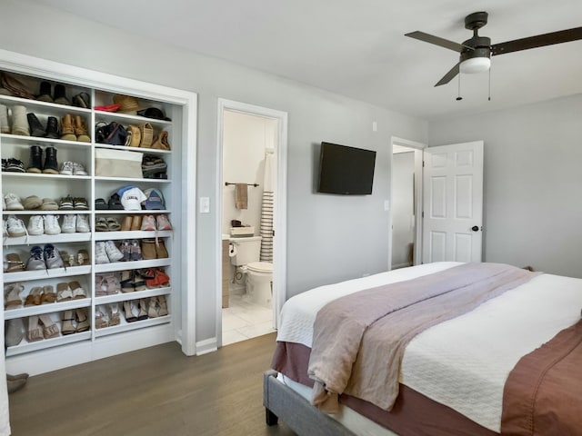 bedroom featuring ceiling fan, dark wood finished floors, and ensuite bathroom