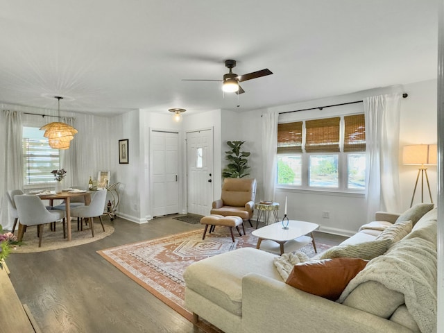 living room featuring dark wood-style floors, plenty of natural light, and baseboards