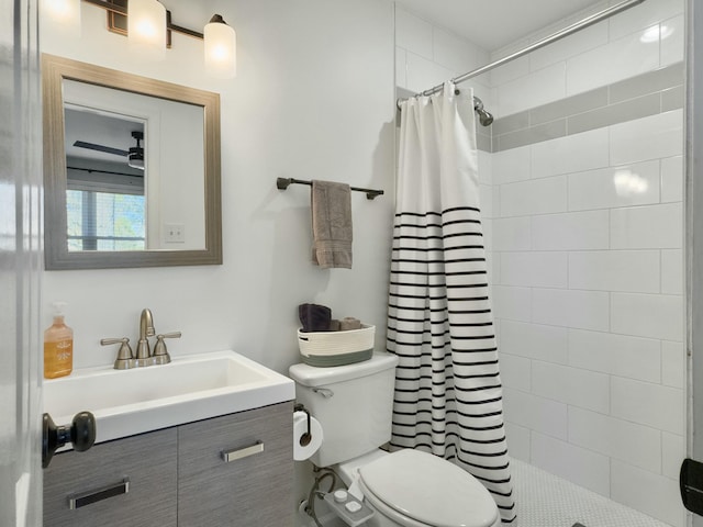 bathroom with tiled shower, vanity, and toilet