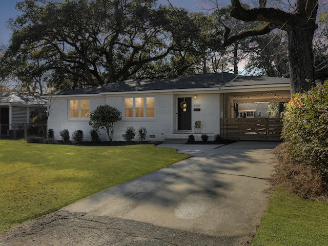 ranch-style home featuring brick siding, concrete driveway, an attached carport, crawl space, and a front yard