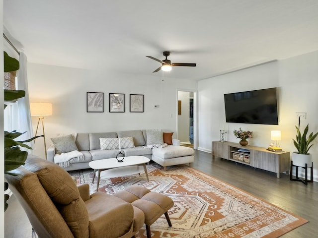 living room featuring ceiling fan, dark wood finished floors, and baseboards