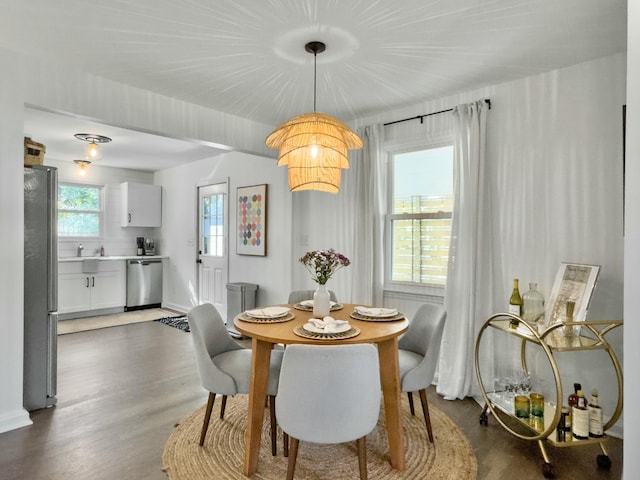 dining space featuring dark wood-style floors and baseboards