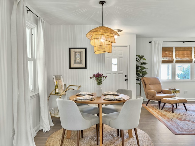 dining room with a notable chandelier, baseboards, and dark wood-style flooring