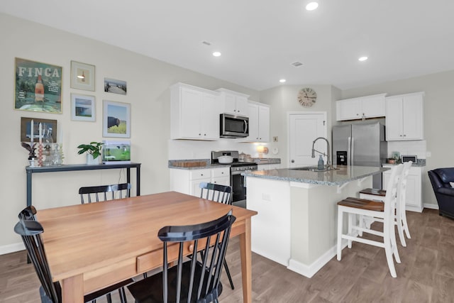 725 Pepperbush St, Charleston, SC 29414 - kitchen featuring stainless steel appliances, a sink, light wood-style floors, a kitchen island with sink, and recessed lighting