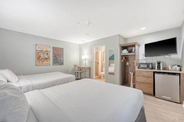 bedroom with fridge, recessed lighting, a bar, light wood finished floors, and ensuite bath