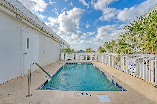 pool with fence and a patio area