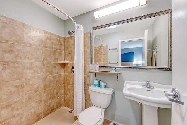 bathroom featuring a sink, a tile shower, and toilet