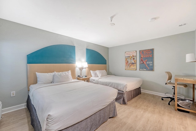 bedroom with baseboards and light wood finished floors