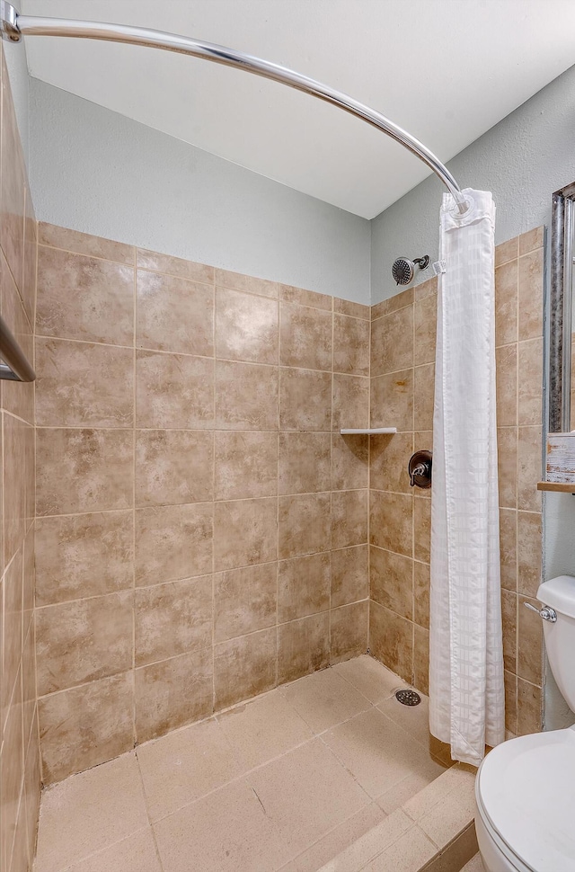 full bathroom featuring toilet and tiled shower