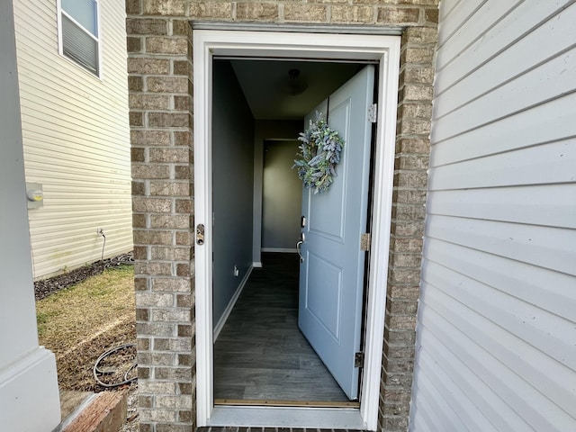 property entrance with stone siding and brick siding