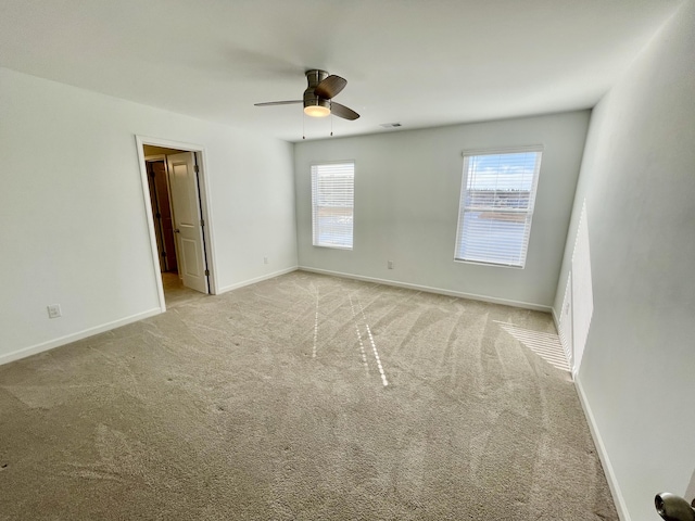 carpeted spare room with ceiling fan