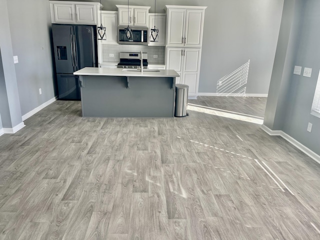 515 Purple Finch Rd, Summerville, SC 29486 - kitchen with stainless steel appliances, light countertops, a sink, an island with sink, and light wood-type flooring