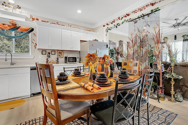 dining area featuring crown molding, plenty of natural light, and sink