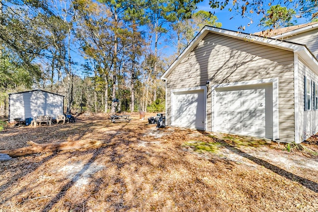 view of home's exterior with a garage and an outbuilding