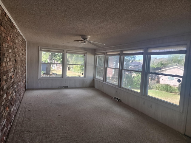 unfurnished sunroom with a wealth of natural light and ceiling fan