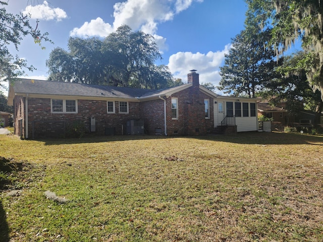 rear view of house featuring a yard