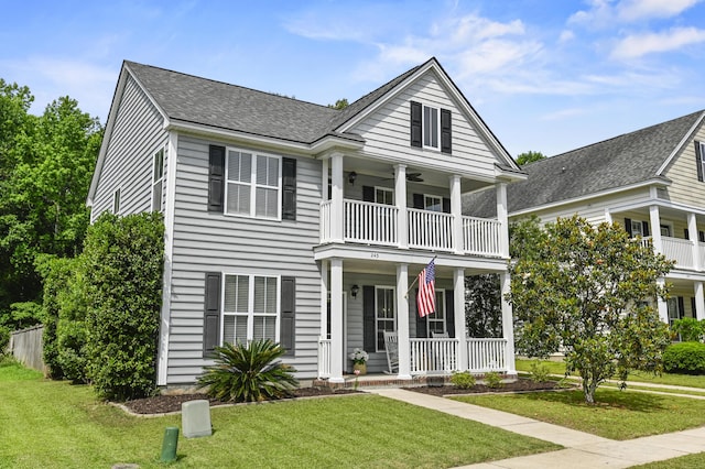 243 Old Savannah Dr, Goose Creek, SC 29445 - neoclassical home with a balcony, covered porch, ceiling fan, a front yard, and roof with shingles