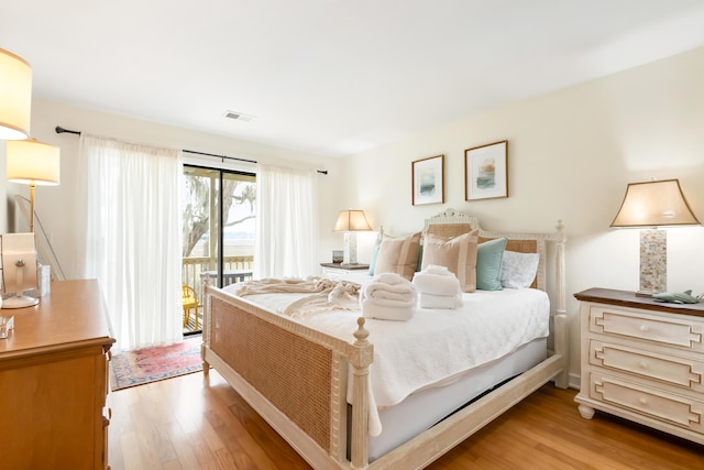 bedroom featuring access to exterior, light wood-style flooring, and visible vents