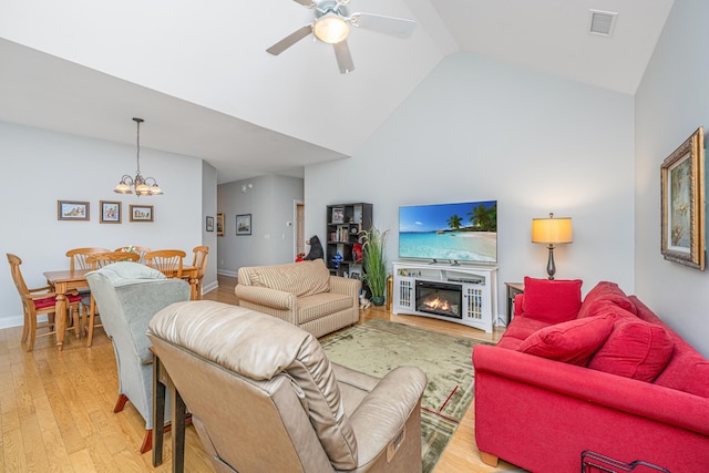 2418 Tuscany Dr, North Charleston, SC 29406 - living room featuring visible vents, high vaulted ceiling, ceiling fan with notable chandelier, light wood finished floors, and a glass covered fireplace