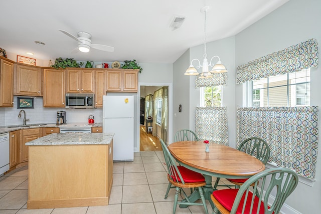 2418 Tuscany Dr, North Charleston, SC 29406 - kitchen featuring white appliances, a center island, tasteful backsplash, a sink, and light tile patterned floors