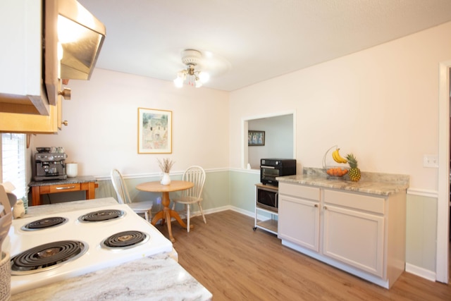 208 Owens Dr, Summerville, SC 29485 - kitchen with light stone countertops, white cabinetry, light wood-type flooring, and white electric range oven