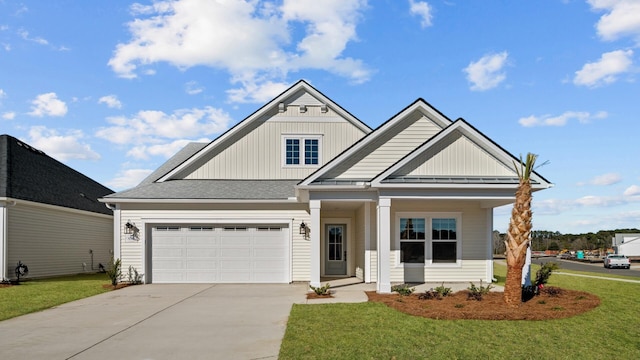 view of front of property with driveway, a garage, a standing seam roof, a front lawn, and board and batten siding