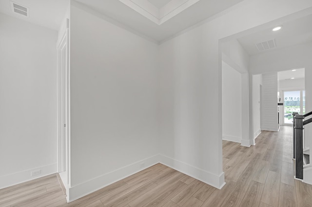 hall with light hardwood / wood-style floors and ornamental molding