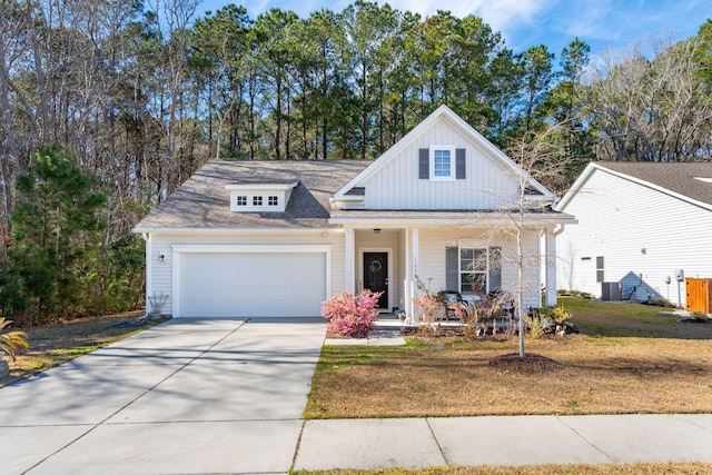 view of front of home featuring covered porch, an attached garage, board and batten siding, driveway, and a front lawn