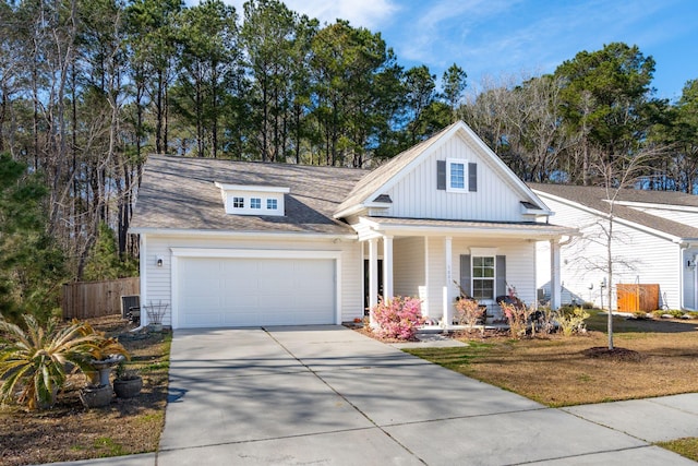 view of front of property featuring driveway, a garage, covered porch, fence, and board and batten siding