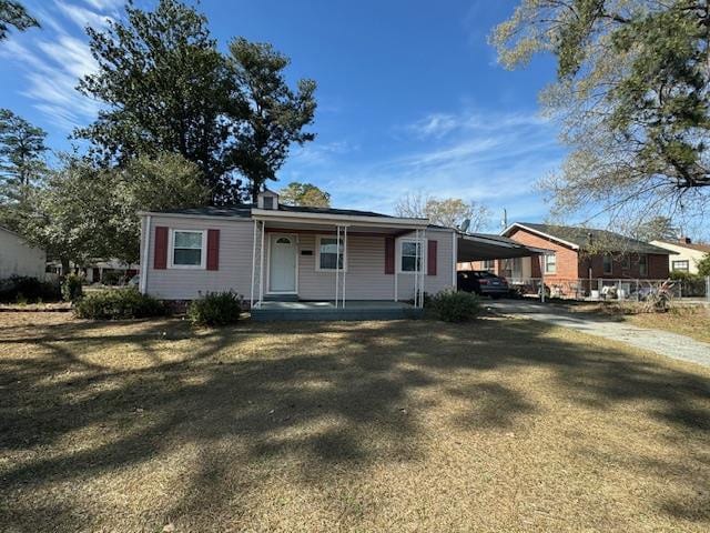 view of front of house with a front lawn and a carport