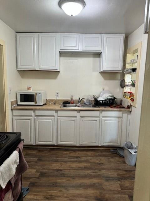 kitchen with white cabinetry, sink, and dark hardwood / wood-style flooring