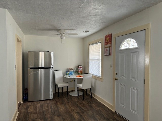 foyer entrance featuring dark wood-type flooring, a textured ceiling, and ceiling fan